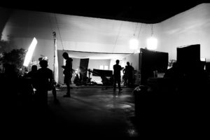 Production crew on set with a green screen.